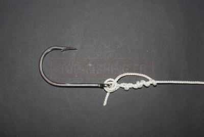 Puis prenez le bout et faites le passer dans la petite boucle située devant l\'œillet.  * Vous comprenez ici la nécessité de conserver suffisamment de fil pour repasser dans la boucle.